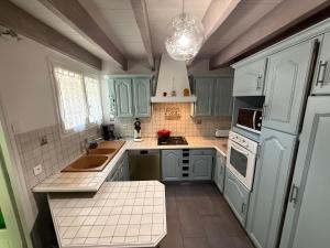 a kitchen with blue cabinets and a sink at Villa La Marpierre in Mondragon
