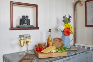 a table with bread cheese and wine and a vase of flowers at Lens Hut in Masbury Station +18 photos