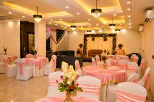 a banquet hall with pink tables and white chairs at Street Studio by Lime Tree Hotel Sector 51 Gurgaon in Gurgaon