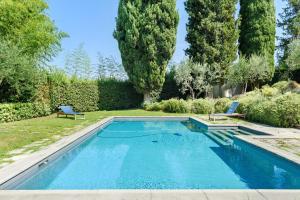 a swimming pool in a yard with two chairs at Villa Pian dei Giullari con Piscina in Florence