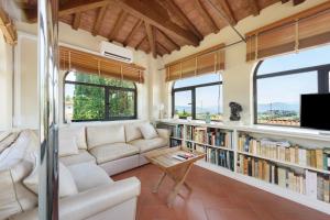 a living room with a couch and bookshelves at Villa Pian dei Giullari con Piscina in Florence