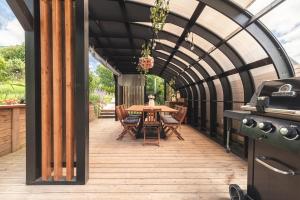 a patio with a table and chairs and a grill at Osada Marchowo in Kielno