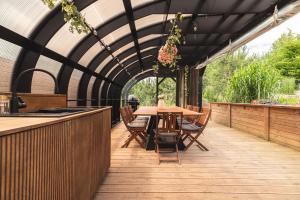 a patio with a table and chairs and a kitchen at Osada Marchowo in Kielno