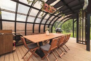 a patio with a wooden table and chairs on a deck at Osada Marchowo in Kielno +89 photos