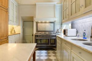 a kitchen with white cabinets and a stove top oven at Villa Pian dei Giullari con Piscina in Florence