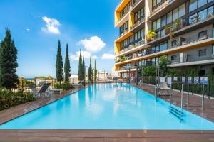 a large swimming pool in front of a building at Mr Elifelet View with a Pool Neve Tsedek in Mashabbe Sade