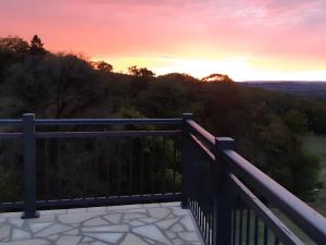 a view from the deck of a house at sunset at Gîte la Roche du Gravillot in Château-Chinon +8 photos