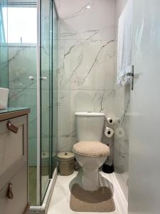 a bathroom with a toilet and a glass shower at Cozy Place Curitiba in Curitiba +25 photos