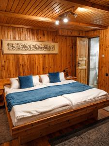 a bedroom with a large bed in a wooden room at Penzión Daria in Batizovce