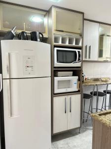 a kitchen with a white refrigerator and a microwave at Cozy Place Curitiba in Curitiba