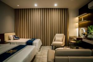 a hotel room with two beds and a chair at T&T Luxury Hotel Đồi Ngô in Bắc Ninh +65 photos