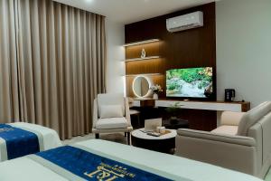 a hotel room with a bed and a tv at T&T Luxury Hotel Đồi Ngô in Bắc Ninh