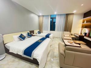 a hotel room with two beds and a couch at T&T Luxury Hotel Đồi Ngô in Bắc Ninh