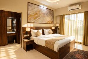 a bedroom with a large bed and a bathroom at The Park Central in Lucknow
