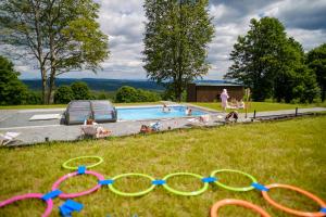 a pool with a group of people in the grass at Willa Zieleniec - apartamenty z Ogrodem SPA in Duszniki Zdrój +56 photos