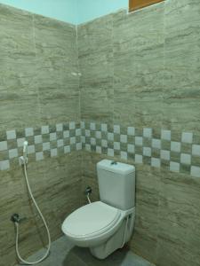 a bathroom with a toilet and a shower at Malar Residency in Tirunallār