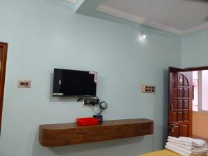 a room with a flat screen tv on a wall at Malar Residency in Tirunallār