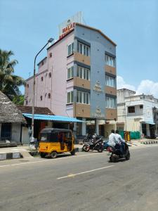 a building on a street with motorcycles at Malar Residency in Tirunallār
