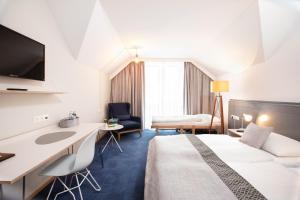 a hotel room with a bed and a desk at Hotel Restaurant Höldrichsmühle in Hinterbrühl +38 photos
