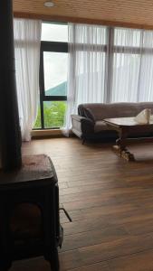 a living room with a couch and a table at Panorama Cottages Tbeti in Shuakhevi +62 photos