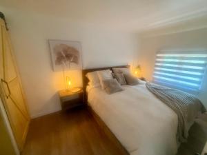 a bedroom with a white bed and a window at La Pergola-1 in Quebec City