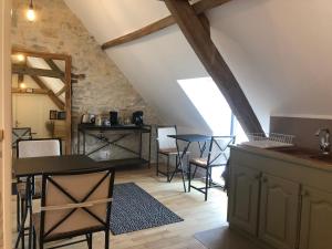 a kitchen with a table and chairs in a attic at Les chambres de Mona in Tauriac