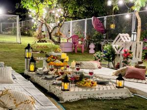 a table with plates of food on it in a yard at EKOSTAY Luxe - Noah Villa with Peddle Court & Sunset View in Lonavala +42 photos