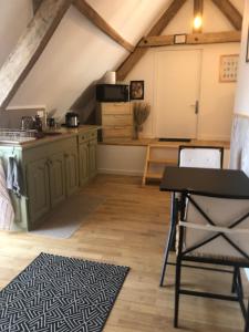 a kitchen and dining room in an attic at Les chambres de Mona in Tauriac +27 photos