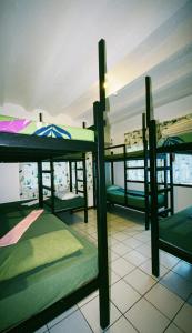 three bunk beds in a room with a window at Screaming Gecko Hostel in Busuanga