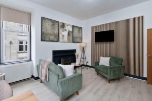 a living room with two chairs and a fireplace at Contractor-Friendly - Hawick - Free Parking - 2BR in Hawick