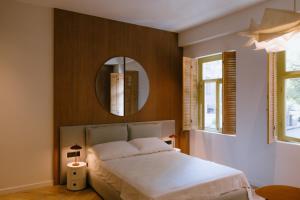a bedroom with a bed and a mirror on the wall at Meidan Heritage Suites Tbilisi in Tbilisi City