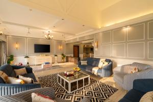 a living room with blue couches and a tv at EKOSTAY Luxe - Noah Villa with Peddle Court & Sunset View in Lonavala