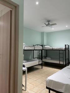 a room with three bunk beds and a ceiling fan at SAN REMO HOSTEL in Athens +25 photos