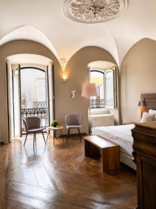 a bedroom with a bed and two chairs and windows at CASA d’OLIVENÇA in Elvas +62 photos