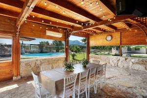 a dining room with a table and chairs and a pool at Villa Aresini - Dimora Esclusiva in Montemiletto