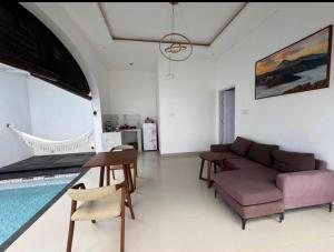 a living room with a couch and a swimming pool at Kama villa in Uluwatu