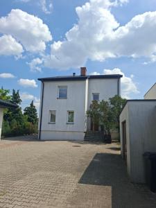 a white house with a brick driveway at Dom na Kościelnej in Ślesin