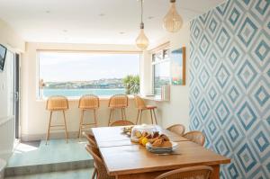 a dining room with a table with a bowl of fruit at 3 Bed Stylish Beachfront Retreat in Roche