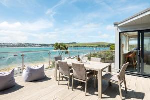 a deck with a table and chairs and the ocean at 3 Bed Stylish Beachfront Retreat in Roche