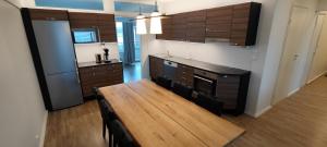 a kitchen with a wooden table and a counter top at Ylätori 2A in Vaasa