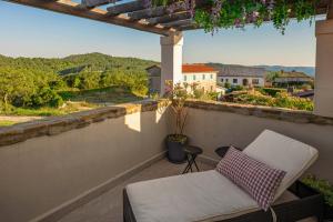 a chair on a balcony with a view at Holiday House Rea with BBQ and two terrace in Sveti Donat