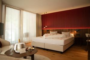 ein Schlafzimmer mit zwei Betten und einer roten Wand in der Unterkunft The Oswald Grand Hotel in Wolkenstein in Gröden + 155 Fotos