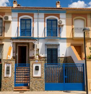 a house with a blue gate in front of it at La Aracelitana in Lucena