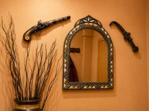 a mirror hanging on a wall with a gun at La Aracelitana in Lucena