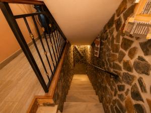 a staircase in a house with a stone wall at La Aracelitana in Lucena