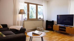 a living room with a couch and a flat screen tv at Ferienwohnung Panoramablick - super für deine Familie und die besten Aussicht in ganz Todtmoos in Todtmoos +19 photos