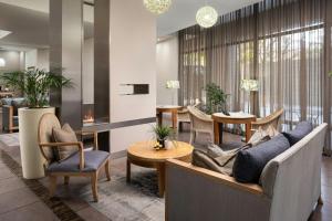 a lobby with a couch and chairs and tables at Protea Hotel by Marriott Cape Town North Wharf in Cape Town