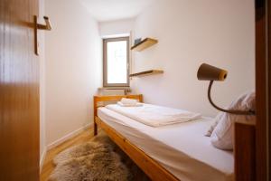 a bedroom with a bed with a lamp and a window at Ferienwohnung Panoramablick - super für deine Familie und die besten Aussicht in ganz Todtmoos in Todtmoos