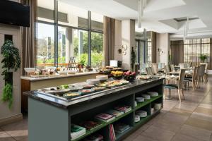 a buffet in a restaurant with food on display at Protea Hotel by Marriott Cape Town North Wharf in Cape Town