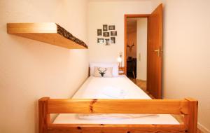 a small bedroom with a bed and a mirror at Ferienwohnung Panoramablick - super für deine Familie und die besten Aussicht in ganz Todtmoos in Todtmoos